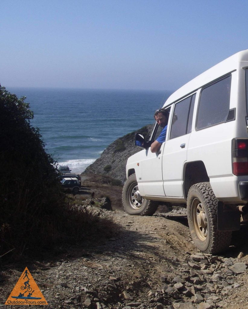 4WD Vehicle driver descending off road to the beach